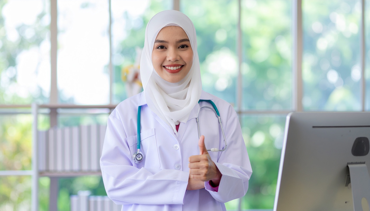 A smiling doctor in a Malaysian GP clinic